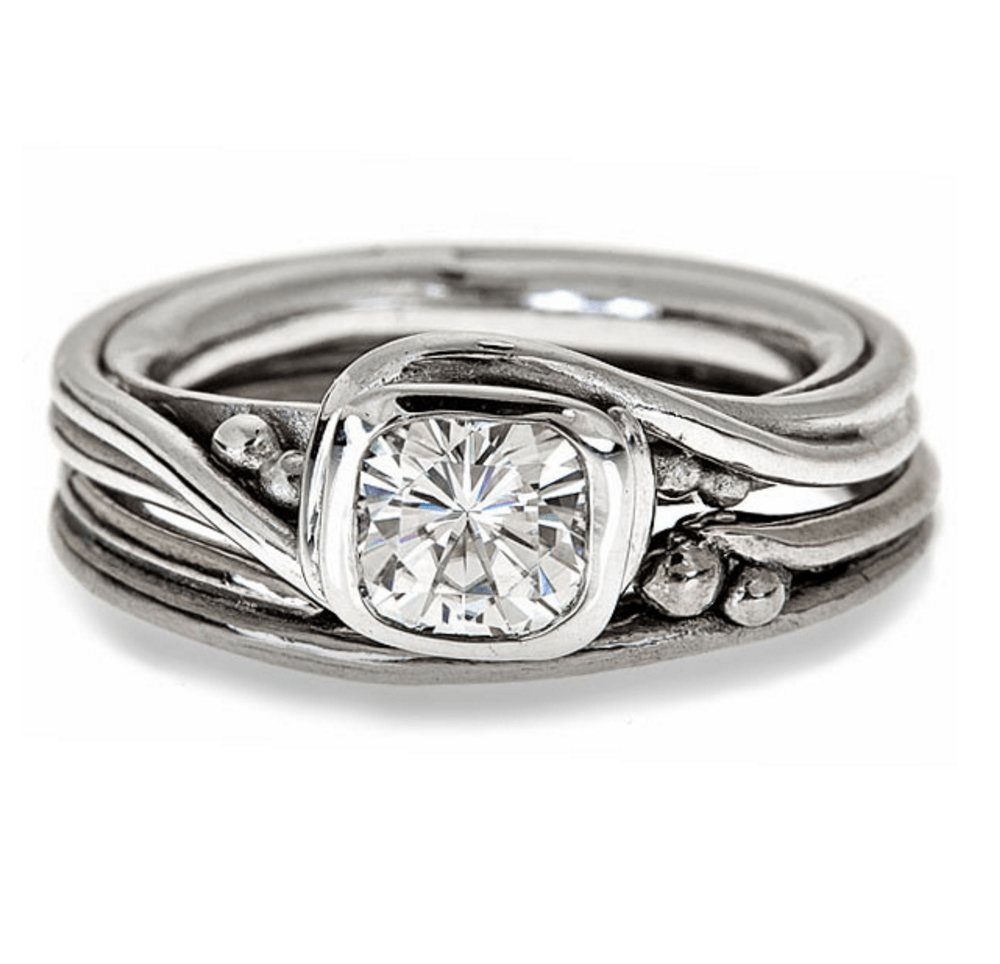 cushion shaped moissanite bezel set into rustic swirling ring setting with matching band