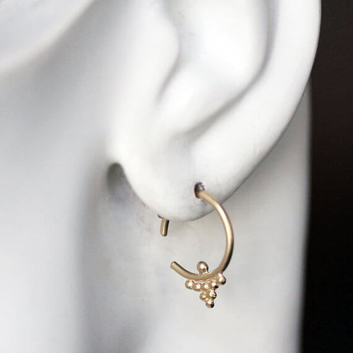 small gold huggie hoop earring in the ear