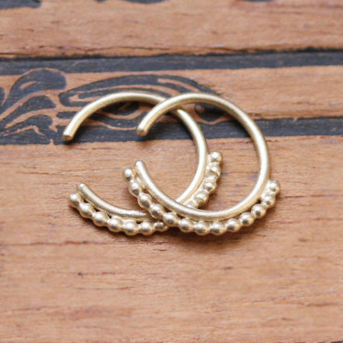 Small huggie hoop earrings with beads lining the front half.