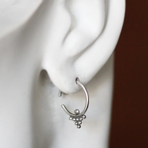 Small silver hoop earring worn on the ear