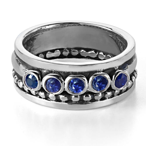 Wide band ring with five blue sapphire stones.