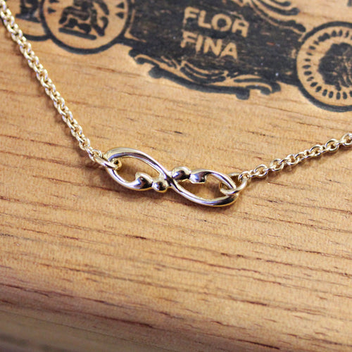 Infinity symbol necklace with bead detailing.