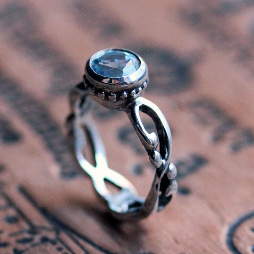 side view of infinity filigree ring that is oxidized and has beaded detail around the bezel