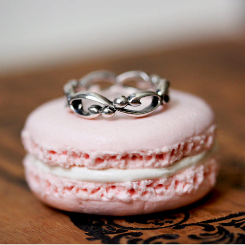 silver infinity filigree band sitting on a pink macaron