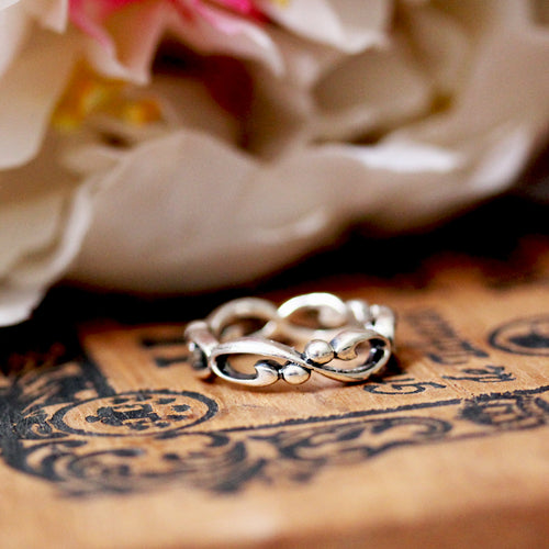 sterling silver infinity wedding band in front of flowers